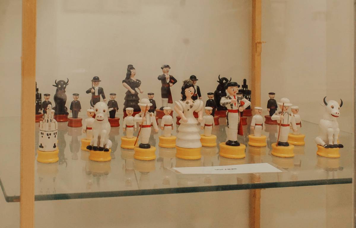 Side-by-side comparison: cluttered figurine shelf vs. minimalist curated display with odd-number groupings, varied heights, and warm lighting