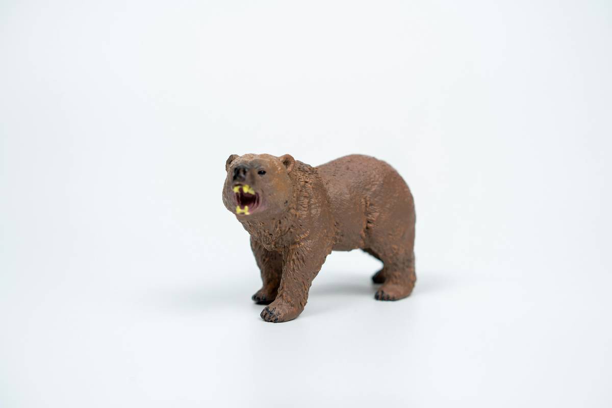 bear figurines home decor styled on wooden shelf with textured books and soft lighting