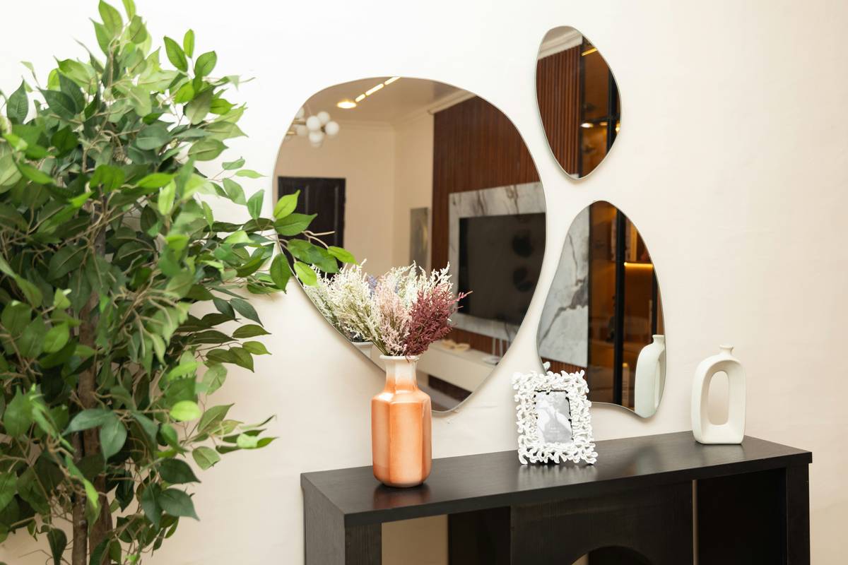 large black figurines home decor displayed on a wooden console table with warm ambient lighting and complementary cream vases